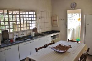 uma cozinha com uma mesa, um lavatório e um balcão em Sossego Homestay em Chapada dos Guimarães