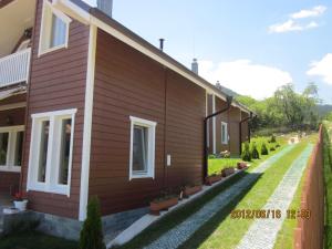 una casa con un patio al lado de un edificio en Holiday Village Orlino en Sarnitsa