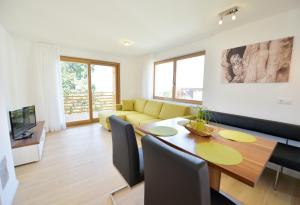 uma sala de estar com uma mesa e um sofá amarelo em Appartment Silvia in St Andrä bei Brixen em Bressanone