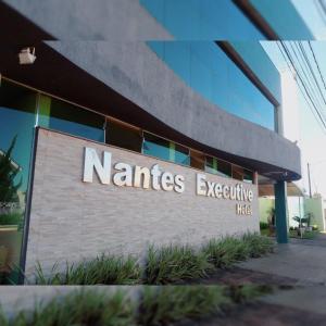 a sign for a nantas executive building at Nantes Executive Hotel in Pitanga