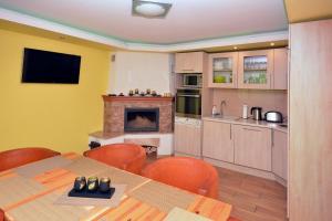 a kitchen and dining room with a table and a fireplace at Pie ābeles in Ventspils