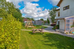a park with a wooden bench and a playground at Pie ābeles in Ventspils