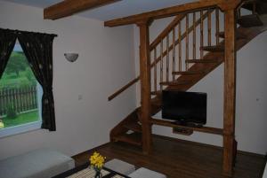 a living room with a staircase with a flat screen tv at Holiday Village Orlino in Sarnitsa