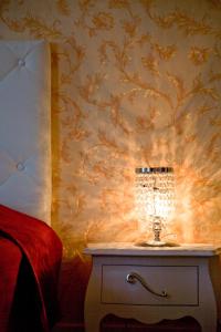 a lamp on a table in a bedroom with a wallpaper at Raffaello Residence in Sassoferrato