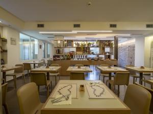 un ristorante con tavoli, sedie e bancone di Hotel Villa Lalla a Rimini