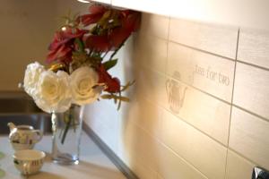 a vase with flowers on a counter next to a wall at Raffaello Residence in Sassoferrato