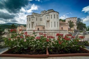 a castle with flowers in front of it at Hotel Delle Rose in Cascia