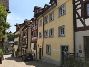 a row of buildings with a car parked in a street at Gaestehaus Seliger in Meersburg