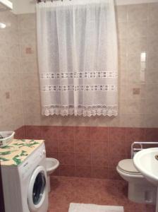 a bathroom with a toilet and a washing machine at Casa Vacanze All'Orizzonte Duino in Duino