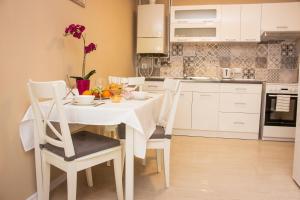 a white kitchen with a white table and chairs at Apartmán U krále Tylova 515 in Jičín
