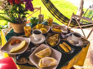 a table with plates of food and cups of coffee at Pousada Da Bell in Barreirinhas
