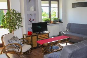 a living room with a couch and a tv at Pokoje Gościnne U Basi in Wilkasy