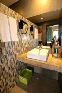 uma casa de banho com um lavatório branco e um espelho. em Lost & Found - Guesthouse & Suites em Albufeira