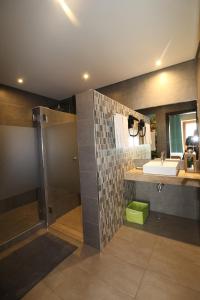 uma casa de banho com um lavatório e um chuveiro em Lost & Found - Guesthouse & Suites em Albufeira