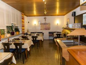 une salle à manger avec des tables et des chaises dans un restaurant dans l'établissement Pension Eichschmid / Röll´n Biergarten, à Bad Gögging