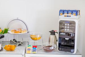 a kitchen counter with a coffee maker and a microwave at Ossuna Bay Hotel Boutique in Cefalù