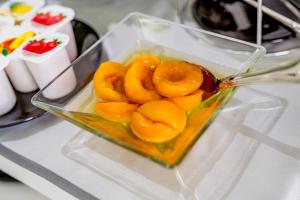 a glass container filled with orange fruit on a table at Ossuna Bay Hotel Boutique in Cefalù
