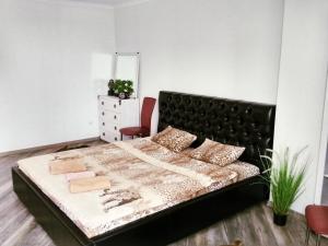 a bedroom with a large bed with a black headboard at Apartment on Morozova in Brest