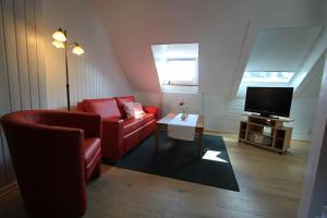 - un salon avec un canapé rouge et une télévision dans l'établissement Haus Victoria, à Marbourg