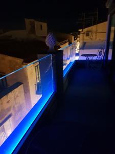 a swimming pool lit up at night with blue lights at Ossuna Bay Hotel Boutique in Cefalù