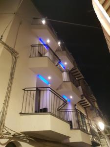 a white building with blue lights on the stairs at Ossuna Bay Hotel Boutique in Cefalù