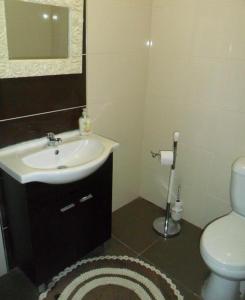 y baño con lavabo, aseo y espejo. en Residencial Ponto Certo, en Vilar Torpim