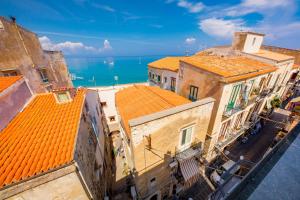 an aerial view of buildings with orange roofs and the ocean at Ossuna Bay Hotel Boutique in Cefalù