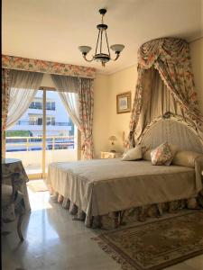 マルベーリャにあるRiyadh House Marbellaのベッドルーム1室(天蓋付きベッド1台、窓付)
