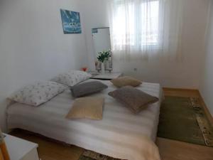 a white bed with pillows on it in a room at Rocco apartments in Pag +51 photos