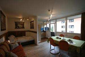 a living room with a bed and a table in a room at Appartements Domizil in Kaprun