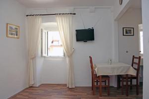 a dining room with a table and a television on a wall at Studio Esperanza Dubrovnik in Dubrovnik