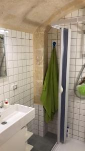 bagno con lavandino, doccia e asciugamano verde di casa vacanza Regina a Grottaglie