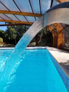 una piscina con agua saliendo de ella en Tulip Inn Honfleur Residence & Spa en Honfleur