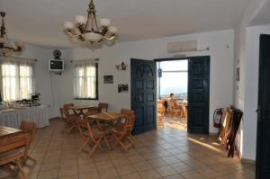 a dining room with a table and chairs and a chandelier at Aiolos Iraklia in Irakleia
