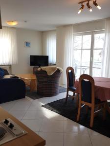 a living room with a table and chairs and a couch at Gästehaus-zum-See in Bad Buchau