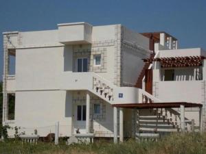 a white building with stairs in front of it at Rocco apartments in Pag