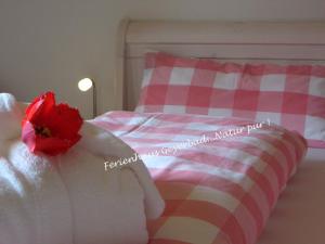 a pink and white bed with a red flower on it at Ferienhaus Geyerbad in Meßstetten