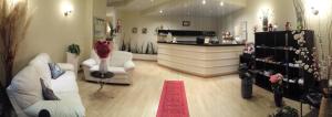 uma sala de estar com dois sofás brancos e um tapete vermelho em Hotel Provenza em Ventimiglia