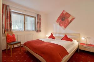 una camera da letto con un grande letto con cuscini rossi di Ferienhaus Gredler a Mayrhofen