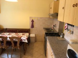 a kitchen with a table with chairs and a sink at Liget nyaralóház in Balatonföldvár