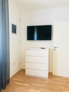ガルプセンにあるKriDa Comfort Ferienwohnungの白いドレッサー(壁に薄型テレビ付)