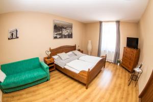 a bedroom with a bed and a green couch at Apartmán U krále Komenského in Jičín