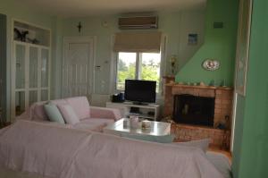 ein Wohnzimmer mit einem rosa Sofa und einem Kamin in der Unterkunft Beach house in Nea Potidaea
