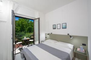 アジェーロラにあるHoliday House D' Anna 68のベッドとバルコニーのある寝室