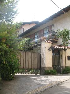 uma casa com um portão de madeira e uma cerca em "LA TAVERNA" B&B em Airuno