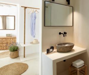 a bathroom with a sink and a mirror at Rocabella Mykonos Hotel in Agios Stefanos