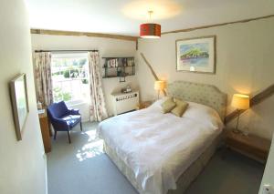 ein Schlafzimmer mit einem Bett, einem Stuhl und einem Fenster in der Unterkunft The Old Rectory, Kettlebaston in Lavenham