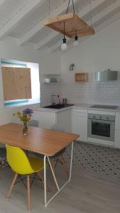 a kitchen with a wooden table and yellow chairs at Casa Aurea in Odeceixe