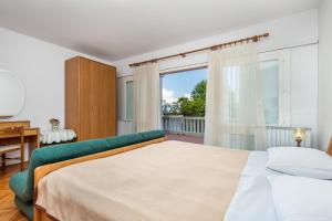 sypialnia z łóżkiem i dużym oknem w obiekcie Rona Apartments Ani w mieście Ičići