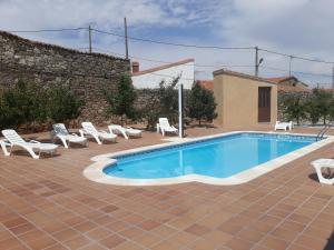 a swimming pool with lounge chairs next to a building at El Pilar de Don Gregorio in Pereruela